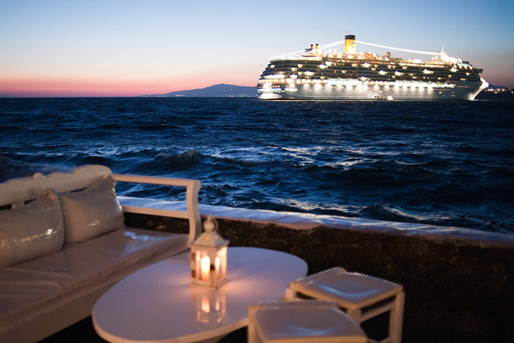Cruise ship in the coast waters of Mykonos island. Cyclades, Agean Sea, Greece.